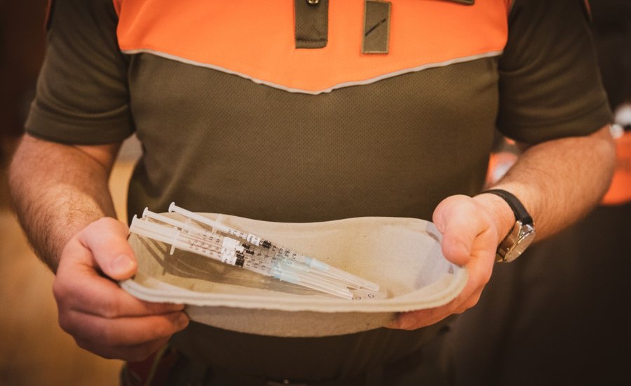 Un astreint portant des vaccins pour injection